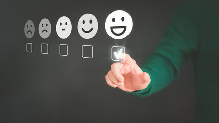 Man touching the virtual screen on the happy smiley face icon to give satisfaction in service....