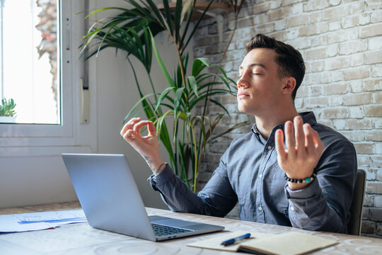 Serene Office Male Employee Sit At Desk Relaxing Doing Yoga, Practice Meditation To Reduce Stress Relief Fatigue Feel Internal Balance At Workplace, Improve Mindfulness, Maintain Mental Health Concept