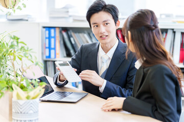 電卓を使って打ち合わせをする人々