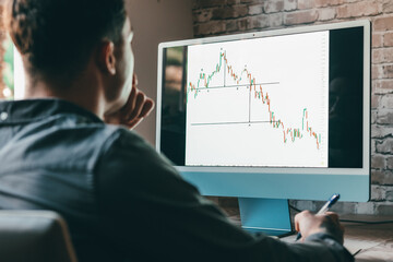 Caucasian business man trader investor analyst looking at financial stock market charts rate dynamic, trading data indexes growth using mobile phone and laptop for cryptocurrency digital analytics..