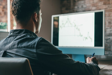 Caucasian business man trader investor analyst looking at financial stock market charts rate dynamic, trading data indexes growth using mobile phone and laptop for cryptocurrency digital analytics..