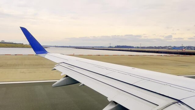 Passenger point of view of aircraft wing during take off from New York airport, USA. First part