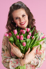 Portrait of happy trendy woman in floral dress on pink