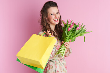 smiling elegant woman in floral dress on pink