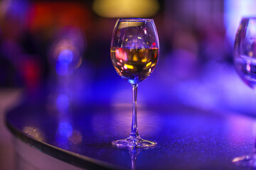 A glass of champagne on the background of lights from the garland. 