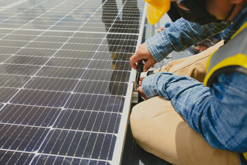 Male technician installing photovoltaic solar modules with screw. Man electrician panel sun...