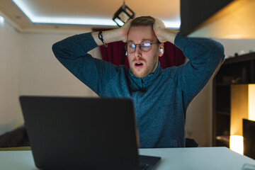 A young man is using his laptop at night for business or studying 