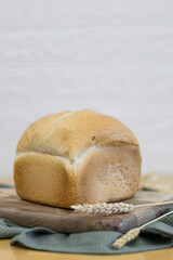 One white round bread with wheat fiber on the table.