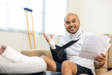 Happy man pay invoice medical expenses from accident fracture broken bone injury with leg splints...