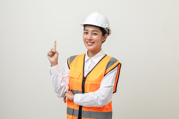 Asian engineer worker woman or architect with white safety helmet standing on isolated white background. Mechanic service factory Professional work job occupation in uniform pointing finger to space