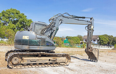 Excavator with Bucket lift up are digging the soil in the construction site on the sky background