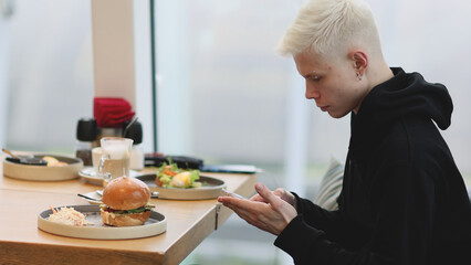 Man Taking Mobile Pictures of Burger with vegetables salad. Social Media Lifestyle