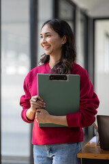 Image of young indian girl asian woman, company worker document file in hand, smiling and holding digital tablet, standing over office background,business black woman holding a cup of coffee and files