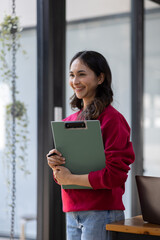 Image of young indian girl asian woman, company worker document file in hand, smiling and holding digital tablet, standing over office background,business black woman holding a cup of coffee and files