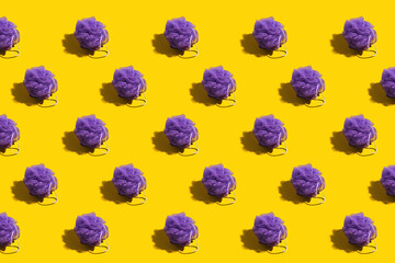 Rows of purple loofahs on a bright yellow background