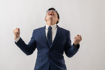 Portrait of excited Asian businessman in glasses standing with win success and excited is positive,...