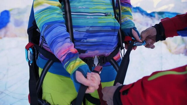 paraglider preparing paraglider equipment with help