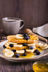 Banana, blueberry and honey toasts on a plate. Homemade dessert. Vertical view