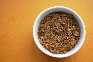  chocolate granola Musli in a bowl on orange background 