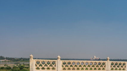 From the terrace of the ancient Red Fort, the white marble Taj Mahal is visible in the distance. In...