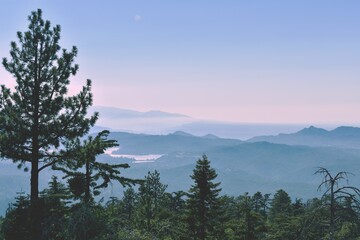 sunrise over the mountains - river and mountain layers with pink and blue clouds