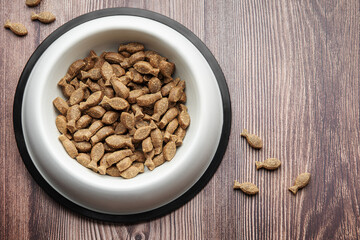 A bowl of dog food on a wooden floor.