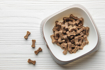 A bowl of dog food on a wooden floor.