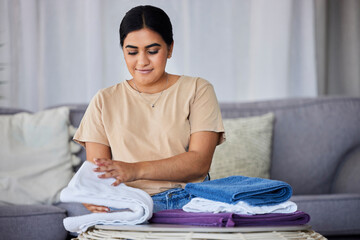 House, cleaning and woman fold laundry on a sofa, happy and relax alone in her home. Towels,...