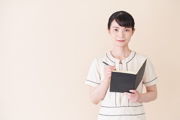 Obraz premium 手帳を書くエステ・美容クリニックの女性