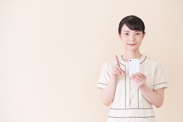 スマートフォンを操作するエステ・美容クリニックの女性