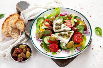 Greek village salad horiatiki with feta cheese, olives, cherry tomato, cucumber and red onion,...