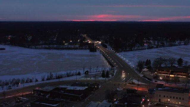 Aerial, Clark Street Bridge in downtown Stevens Point Wisconsin in the evening during winter. View of Wisconsin River