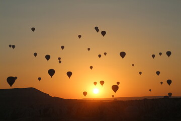Hot air balloon flying over fairy chimneys and rock landscape at Cappadocia Turkey