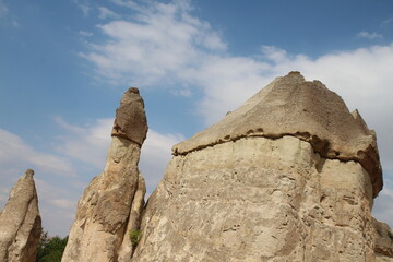 Fototapeta na wymiar Hot air balloon flying over fairy chimneys and rock landscape at Cappadocia Turkey