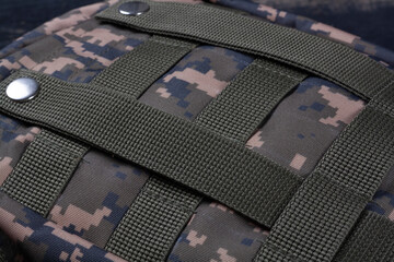 Military first aid kit in camouflage color close-up on a wooden background. First aid for wounds...
