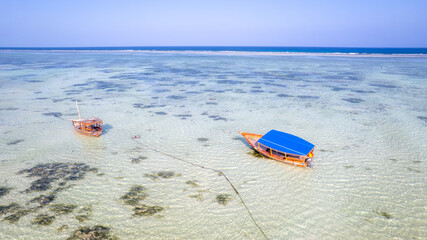 Traditional boat on beautiful beach and tropical sea at low tide in Jambiani, Zanzibar, Tanzania Africa