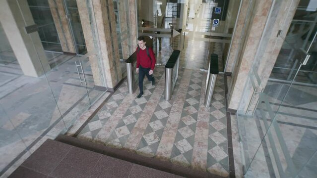 View from security cameras at the entrance and reception in hotel or business center office. People enter and exit through glass doors and turnstile. Concept of tracking system, monitoring and safety.