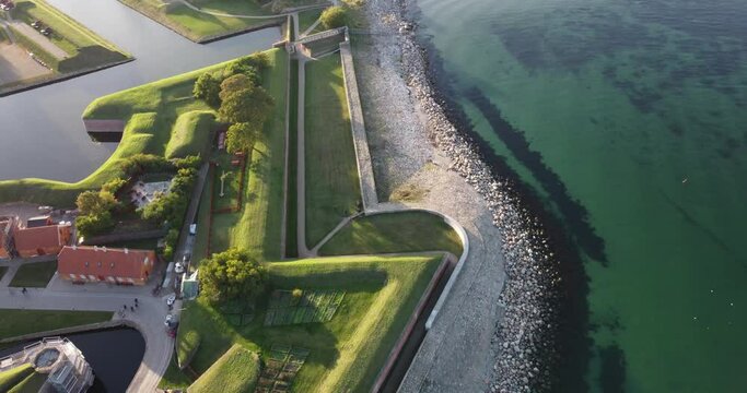 It is the view of the surroundings of Kronborg Castle, Denmark. You can see its defensive walls. As well as the beach bathed by the North Sea.