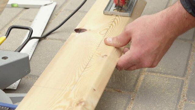 Video of unrecognizable man hands cutting with electrical saw and jack plane wooden timber outdoors. Woodwork for craftsman. Carpenter work, small business for furniture and house repairing. Full hd