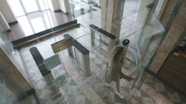 View from security cameras at the exit in the hotel or business center office. People or workers enter and exit through glass doors and turnstile. Concept of tracking system, monitoring and safety.