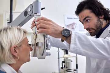 Senior woman in a vision test or eye exam for eyesight by doctor, optometrist or ophthalmologist...
