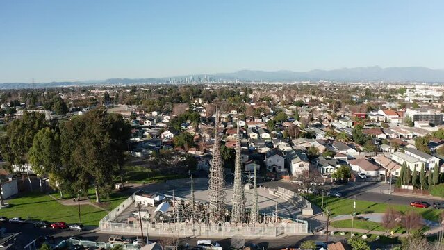 Close-up panning aerial shot of the Watts Towers with downtown Los Angeles in the background. 4K