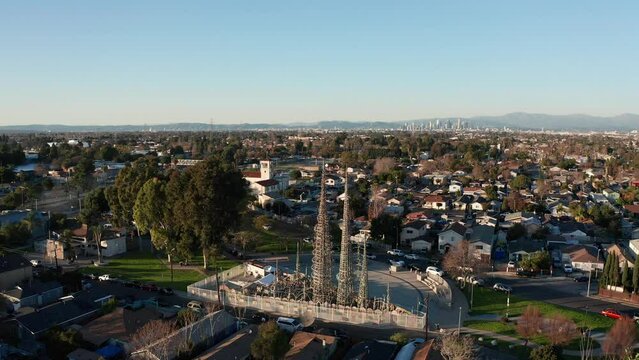 Aerial panning shot of the Watts Towers with downtown Los Angeles in the distance. 4K