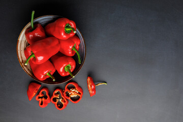 Top view of a washed and wet red ripened Hungarian Leutschauer paprika peppers in a bowl homegrown from a kitchen garden with space for text
