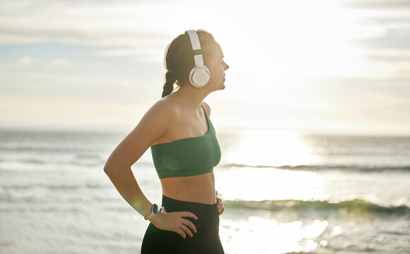 Sunshine headphones and woman on beach, fitness and streaming music for peace, balance or resting. Female, lady or confident athlete with headset, sunlight or seaside for running, workout or exercise