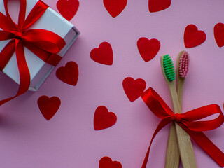 Flat lay with a lot of tiny heart-shaped papers, white gift box, two toothbrushes and space for...