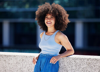 Fototapeta na wymiar Portrait, fashion and city with a black woman outdoor on a bridge, looking relaxed during a summer day. Street, style or urban and an attractive young female posing outside with an afro hairstyle