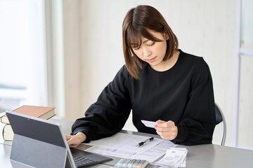 会計ソフトに経費を入力するアジア人女性