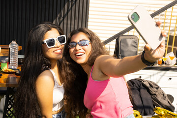 cheerful young indian girl friends taking a selfie together outdoor in summer. Technology, Friendship. 