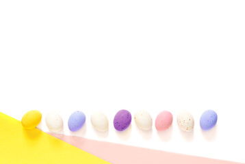 candy Easter eggs on a light white 
pink and yellow background. Happy easter flat lay. copy space